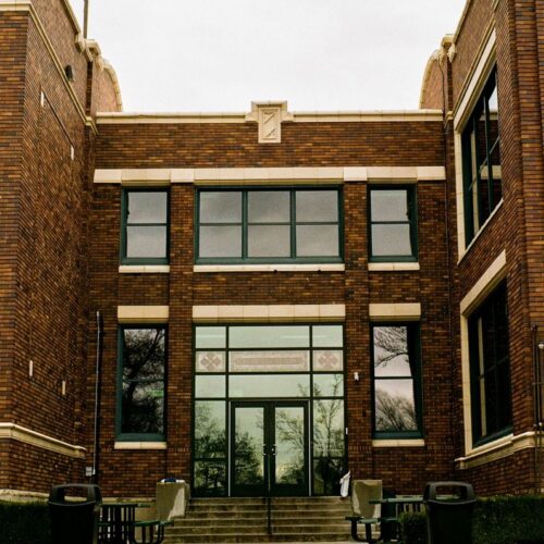 A front view of a classic university building with a brick facade, capturing urban architecture.